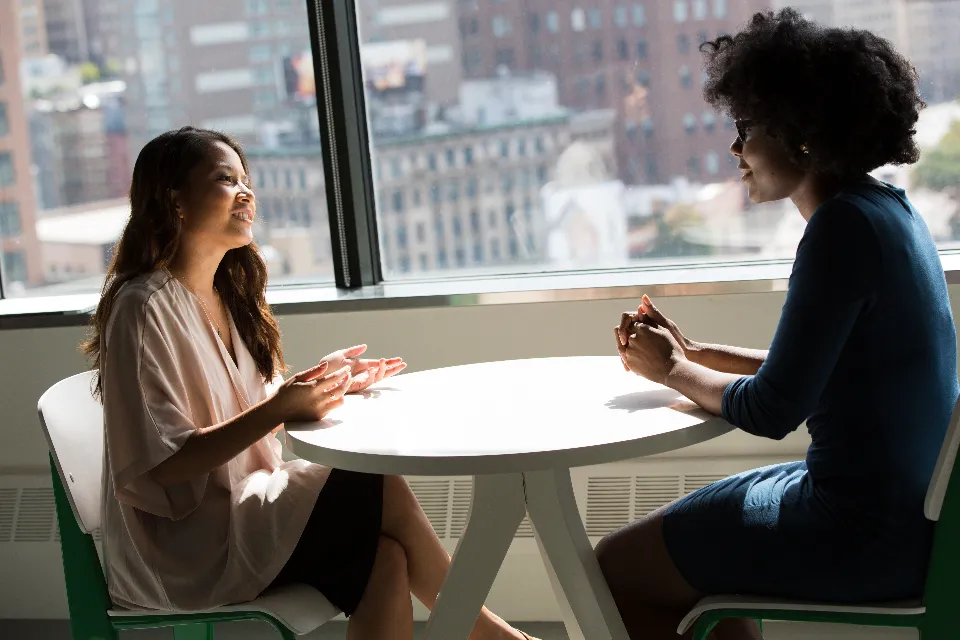 Zwei Frauen besprechen sich an einem Tisch im Büro